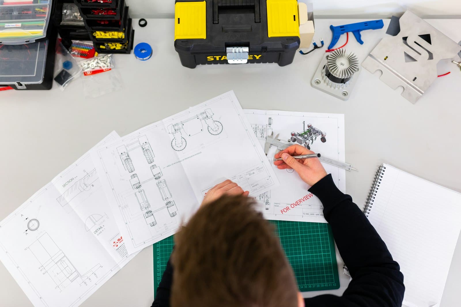 Technical drawings and tools on an engineering desk
